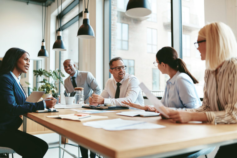 Smiling diverse businesspeople talking together around an office