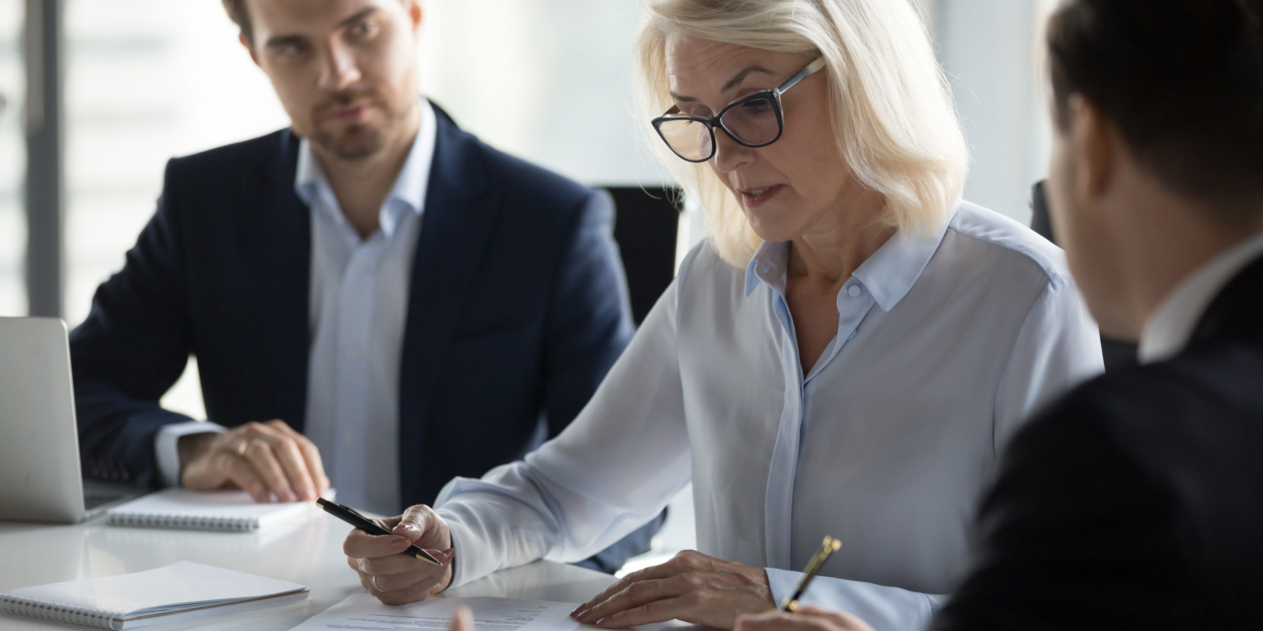 Concentrated aged businesswoman checking agreement before signin